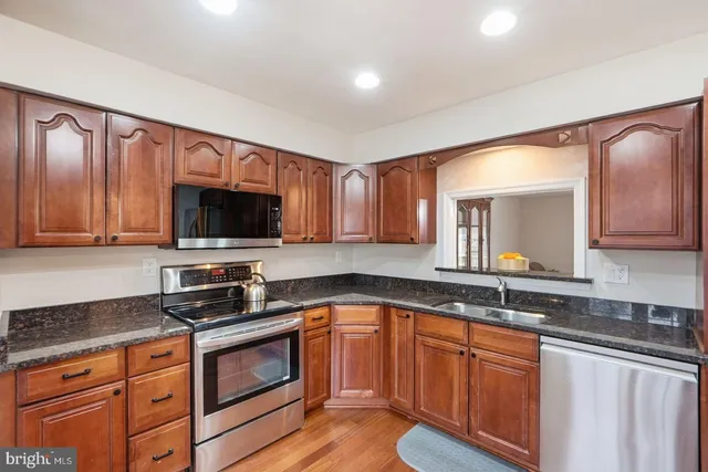 a kitchen with granite countertop a sink and steel appliances