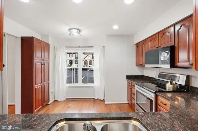 a kitchen with granite countertop a stove and a sink