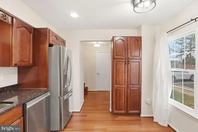 a view of a refrigerator in kitchen and wooden floor