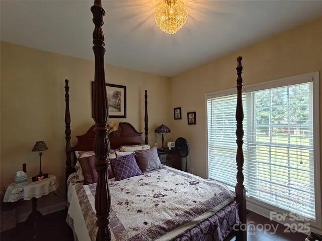a bed room with a bed window and a chandelier