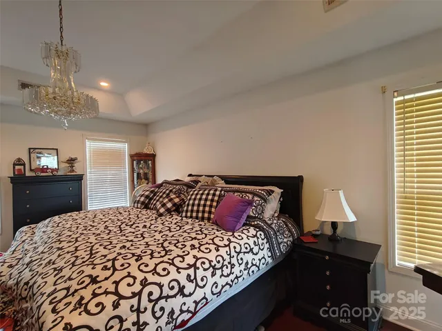 a bedroom with a bed and a lamp on dresser