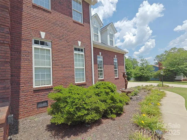 a view of a brick house with a yard
