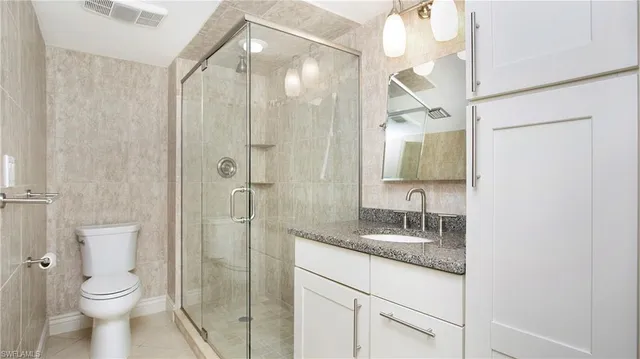 a bathroom with a granite countertop sink toilet and shower