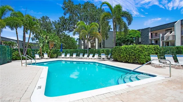 a view of swimming pool with outdoor seating and plants