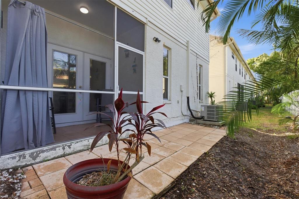 3221 Meta Court Largo, FL 33771 - Photo 33 of 40 a patio with table and chairs and potted plants