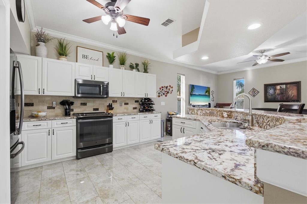 3221 Meta Court Largo, FL 33771 - Photo 7 of 40 a kitchen with stainless steel appliances granite countertop a sink stove oven and white cabinets