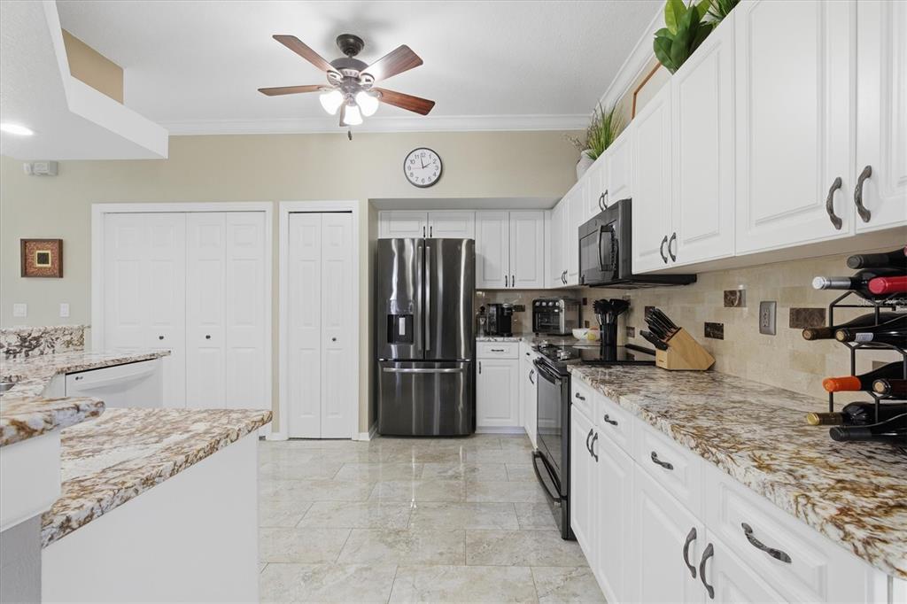 3221 Meta Court Largo, FL 33771 - Photo 10 of 40 a kitchen with a refrigerator a stove cabinets and living room view