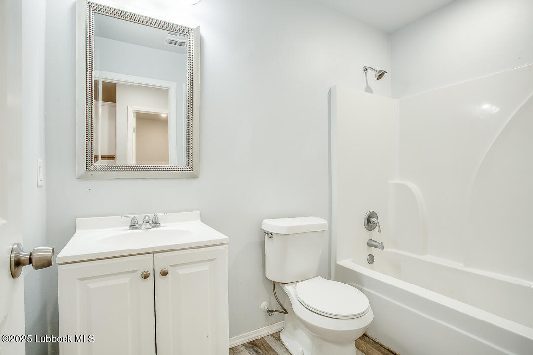5514 Jarvis Street Lubbock, TX 79416 - Photo 15 of 16 a white toilet sitting next to a bathroom sink