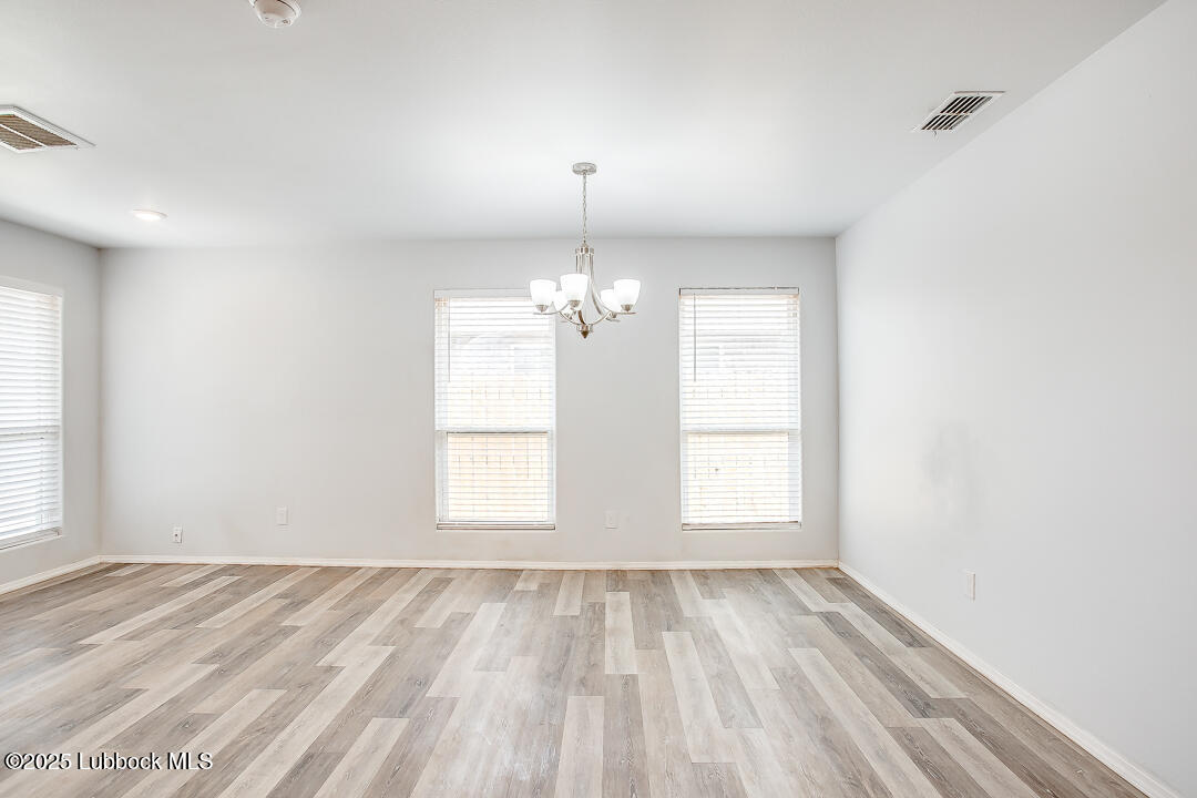 5514 Jarvis Street Lubbock, TX 79416 - Photo 5 of 16 wooden floor in an empty room with a window
