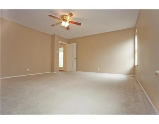 a view of an empty room with a ceiling fan