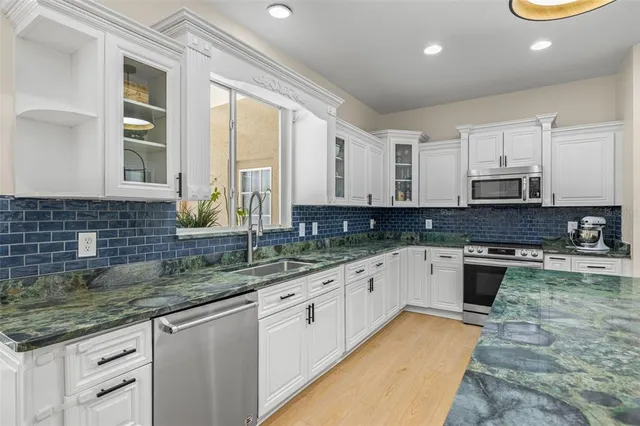 a kitchen with granite countertop a refrigerator and a sink