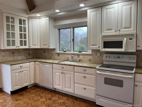 a kitchen with granite countertop a stove sink and cabinets