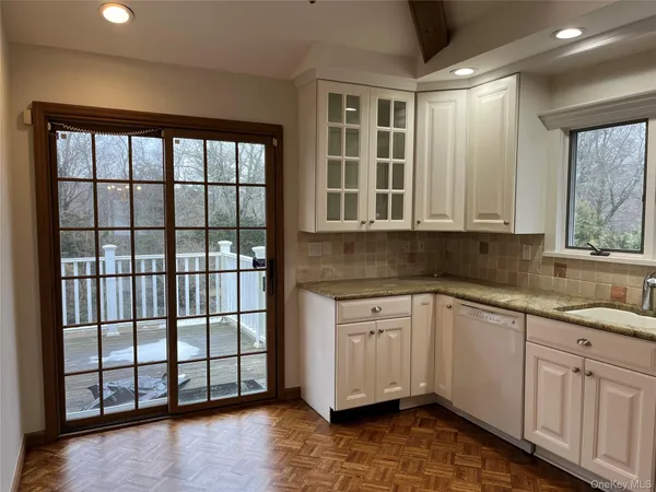 a kitchen with stainless steel appliances granite countertop a stove a sink and a white cabinets
