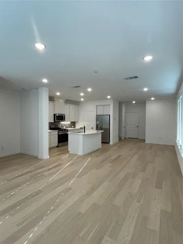 a view of kitchen with kitchen island and stainless steel appliances