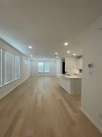 a view of kitchen with kitchen island a sink wooden floor and a refrigerator