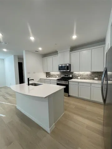 a kitchen with stainless steel appliances a white stove top oven sink and cabinets