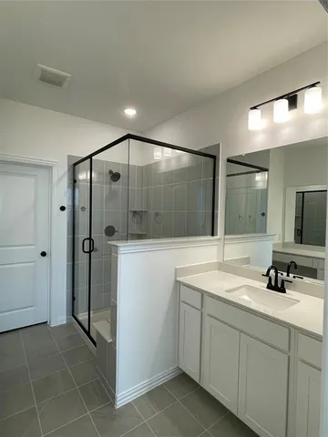a spacious bathroom with a shower sink and mirror