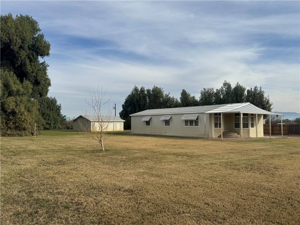 View of front facade with a front yard, an outbuilding, and entry steps