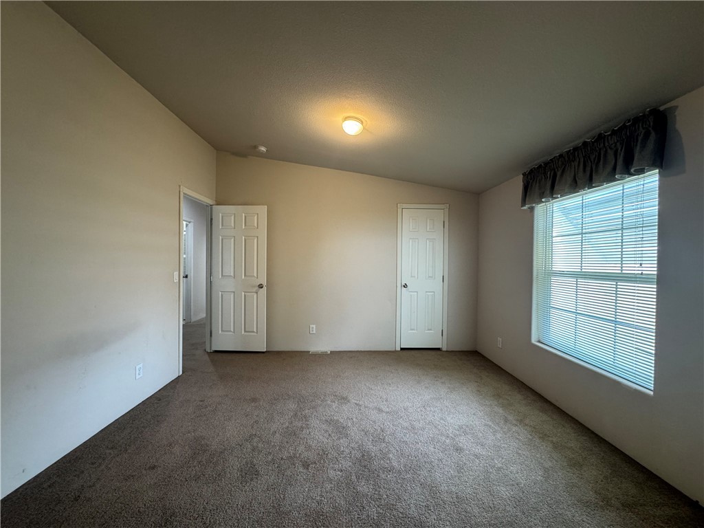 10044 Kent Road Mohave Valley, AZ 86440 - Photo 14 of 25 Unfurnished bedroom with vaulted ceiling and carpet