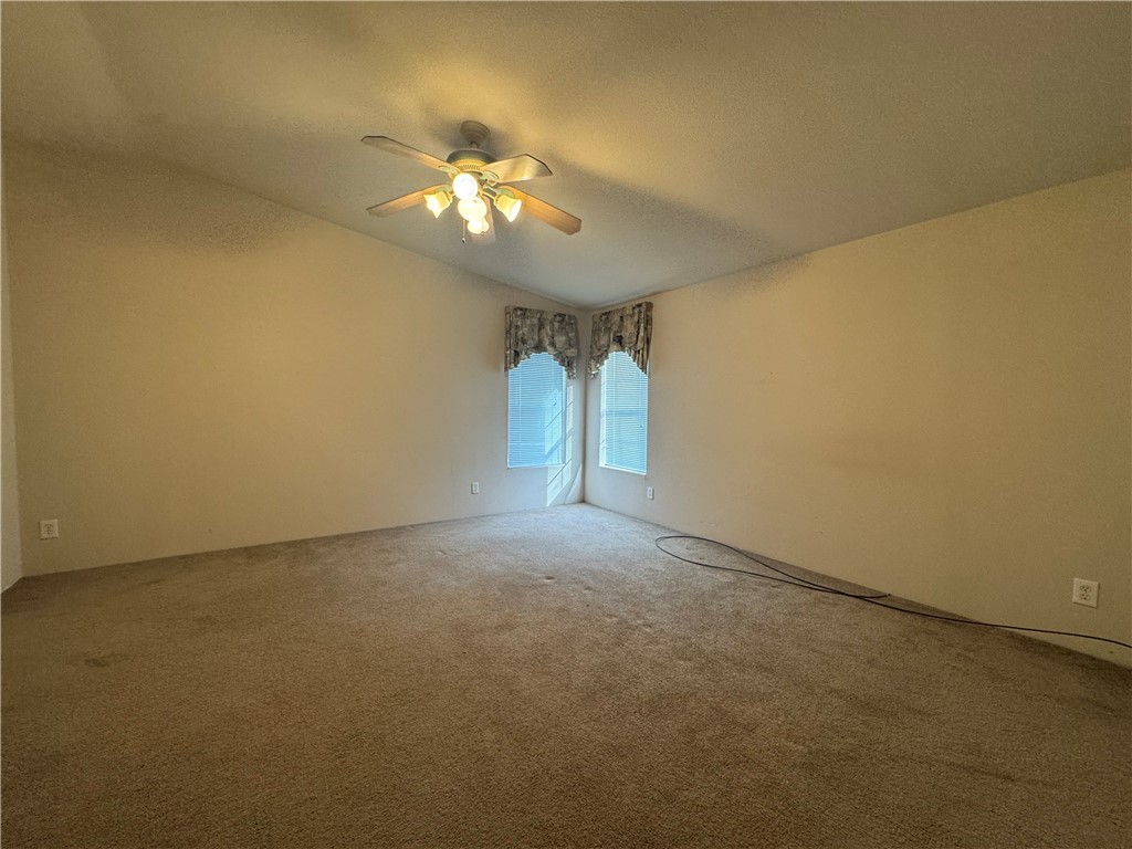 10044 Kent Road Mohave Valley, AZ 86440 - Photo 16 of 25 Empty room with carpet flooring, ceiling fan, and a textured ceiling
