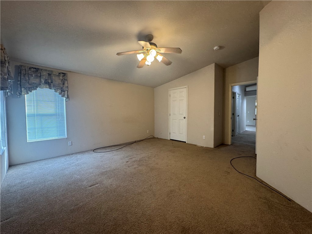 10044 Kent Road Mohave Valley, AZ 86440 - Photo 18 of 25 Unfurnished bedroom featuring lofted ceiling, carpet flooring, ceiling fan, and a textured ceiling