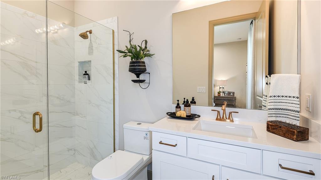 15680 Cassio Way Naples, FL 34114 - Photo 12 of 36 a bathroom with a sink a toilet and shower
