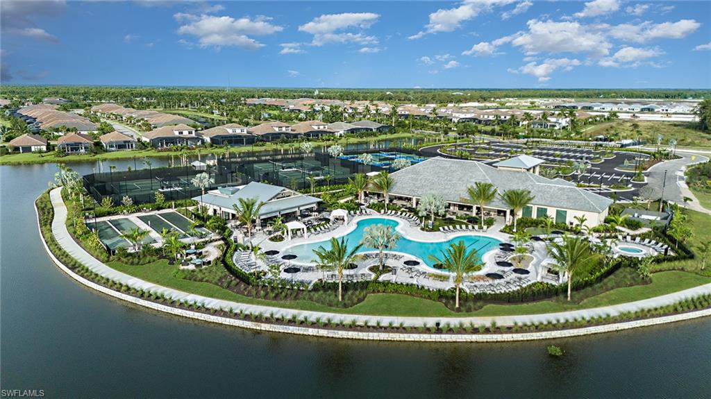 15680 Cassio Way Naples, FL 34114 - Photo 24 of 36 a view of a swimming pool with a table and chairs