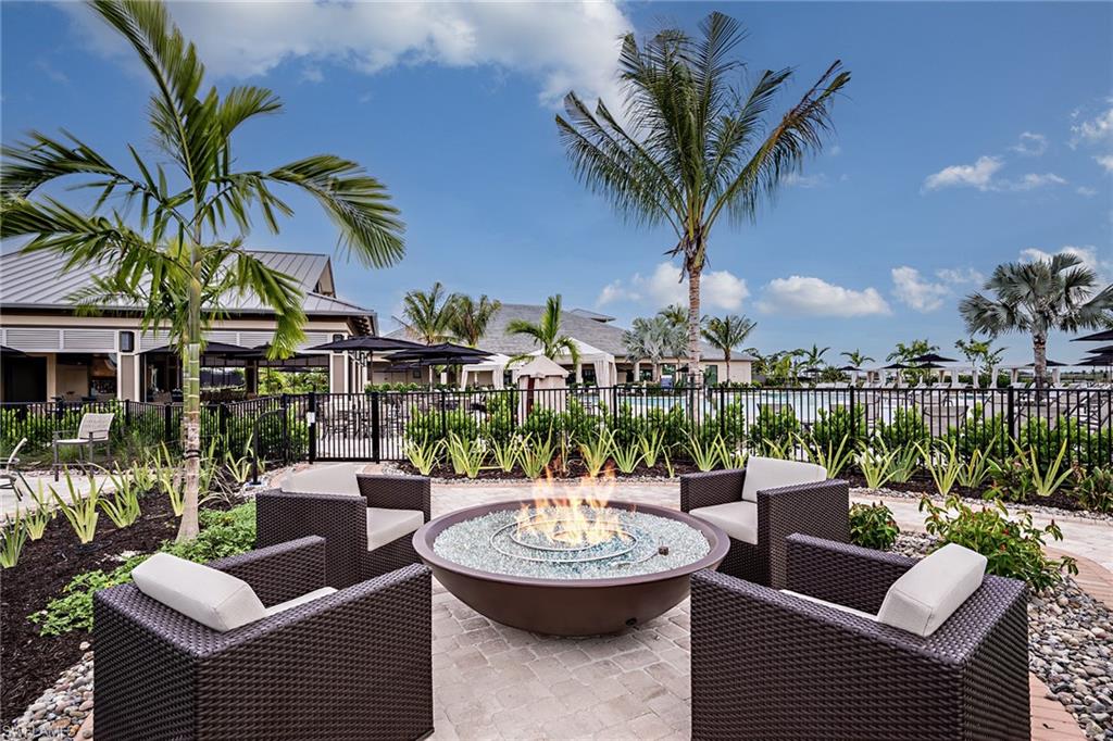 15680 Cassio Way Naples, FL 34114 - Photo 28 of 36 a view of a patio with couches and a fire pit and potted plants