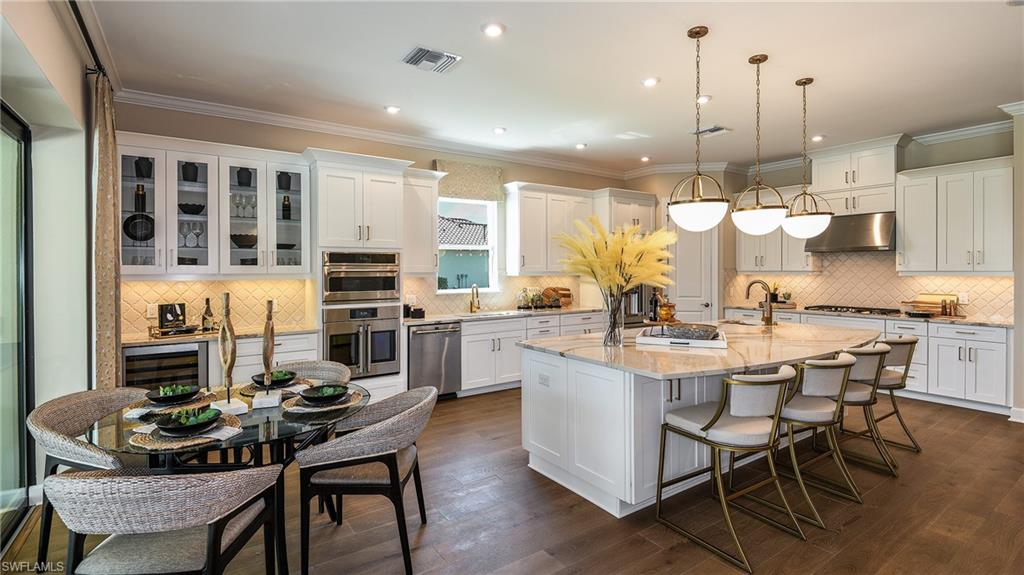15680 Cassio Way Naples, FL 34114 - Photo 6 of 36 a kitchen with a dining table chairs and white cabinets