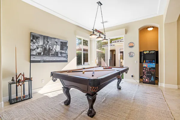 a room with chandelier fan and wooden floor