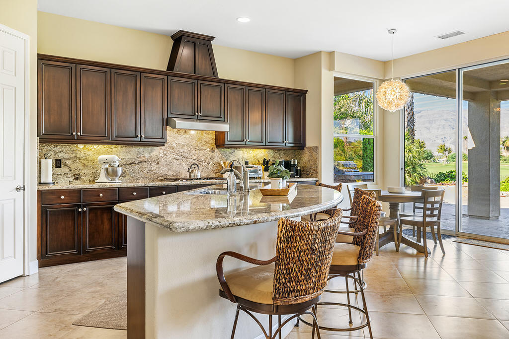 56825 Mountain View La Quinta, CA 92253 - Photo 5 of 30 a kitchen with granite countertop a table chairs stove and cabinets