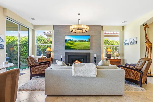 a living room with fireplace furniture and a large window