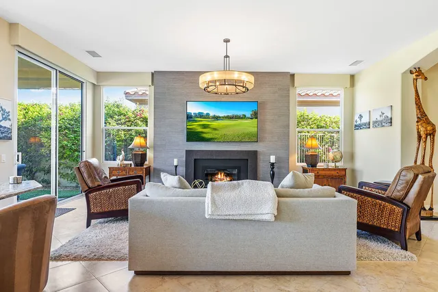a living room with fireplace furniture and a large window