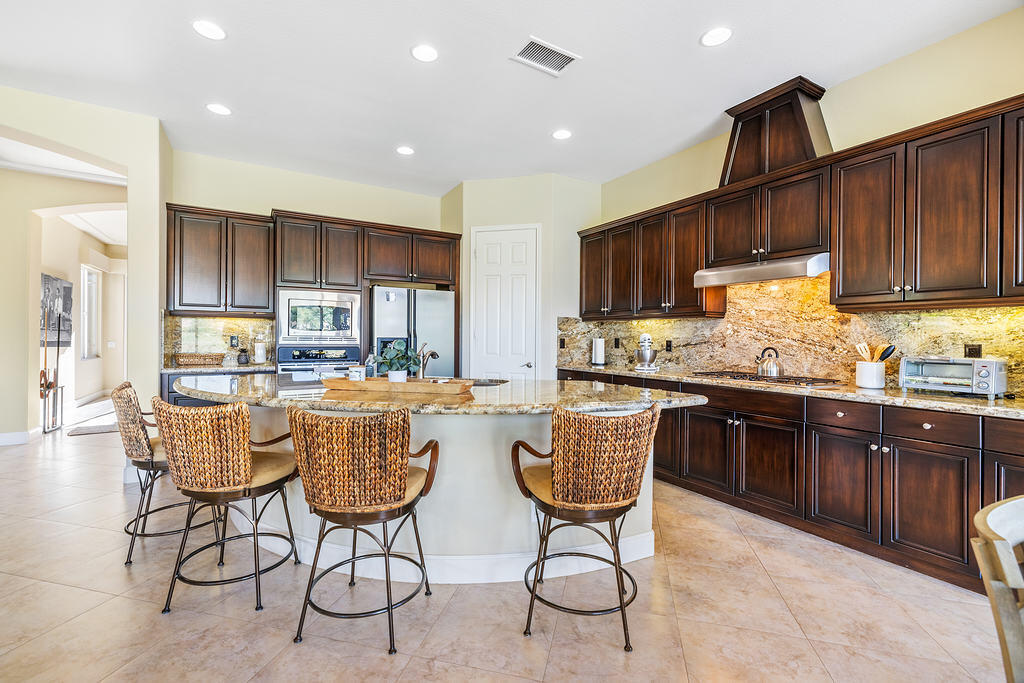 56825 Mountain View La Quinta, CA 92253 - Photo 10 of 30 a kitchen with granite countertop wooden cabinets a dining table and chairs