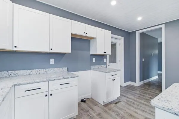 a kitchen with granite countertop white cabinets and white appliances