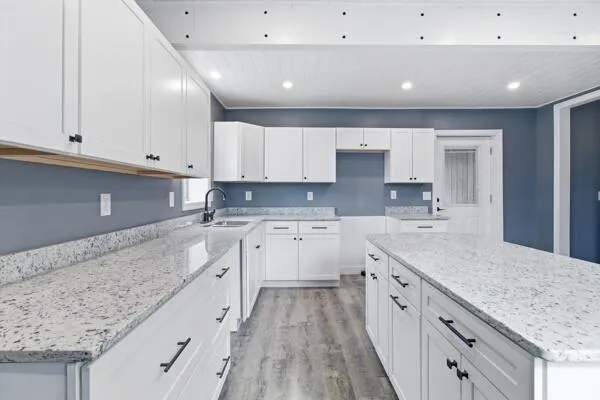 a large kitchen with stainless steel appliances granite countertop a lot of counter space and wooden floors
