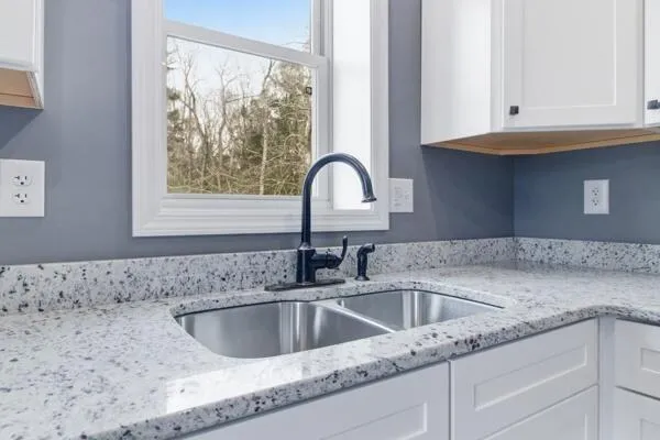 a kitchen with granite countertop a sink and a window