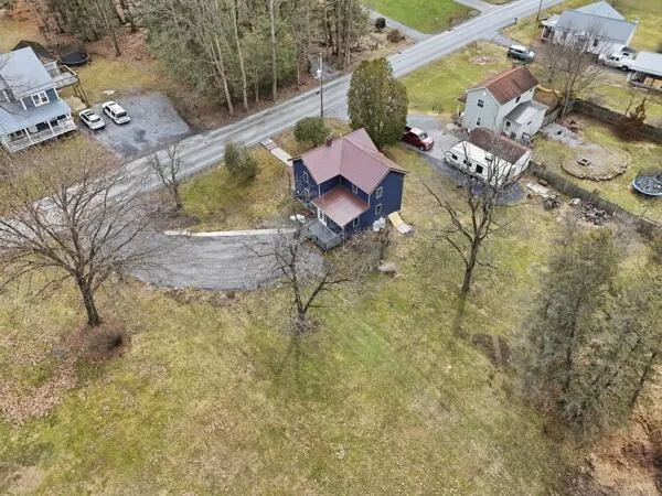 a aerial view of a house with swimming pool and large trees