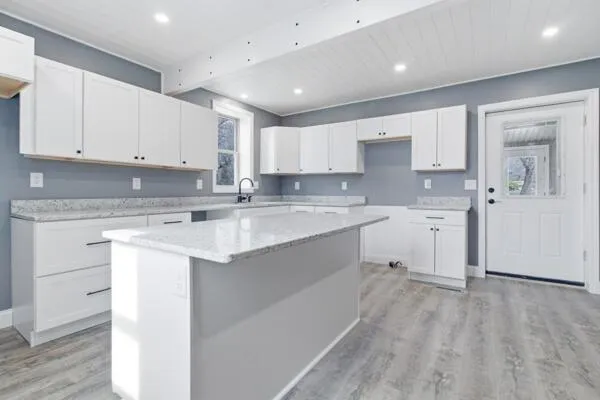 a kitchen with a sink window and cabinets