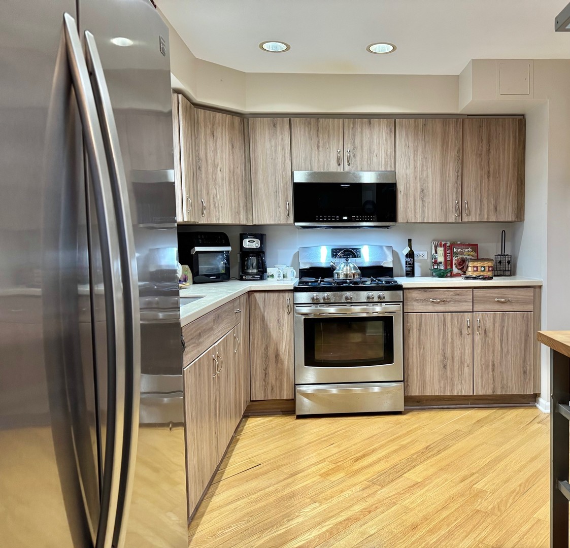 1325 Perry Street, Unit 606 Des Plaines, IL 60016 - Photo 19 of 25 a kitchen with a sink a stove a microwave and a refrigerator