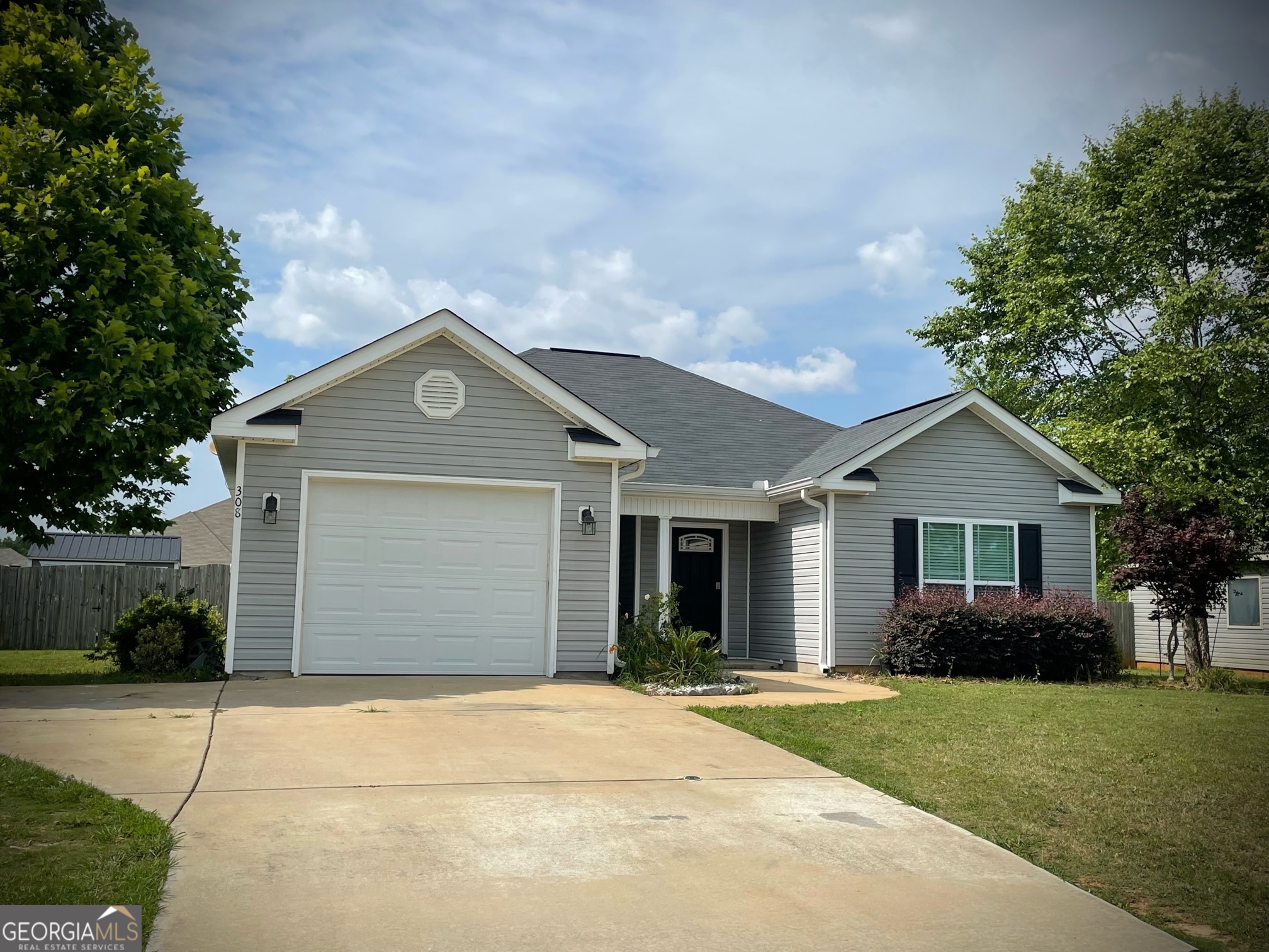 a front view of a house with a garden and garage