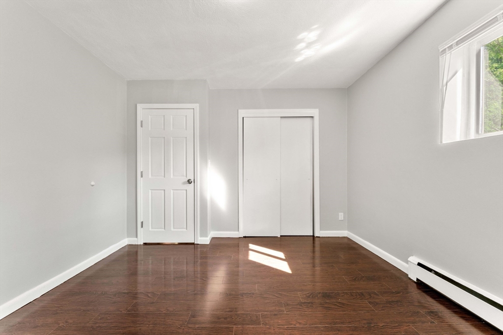 46 Westgate Road, Unit 3 Chestnut Hill, MA 02467 - Photo 8 of 16 an empty room with wooden floor and windows