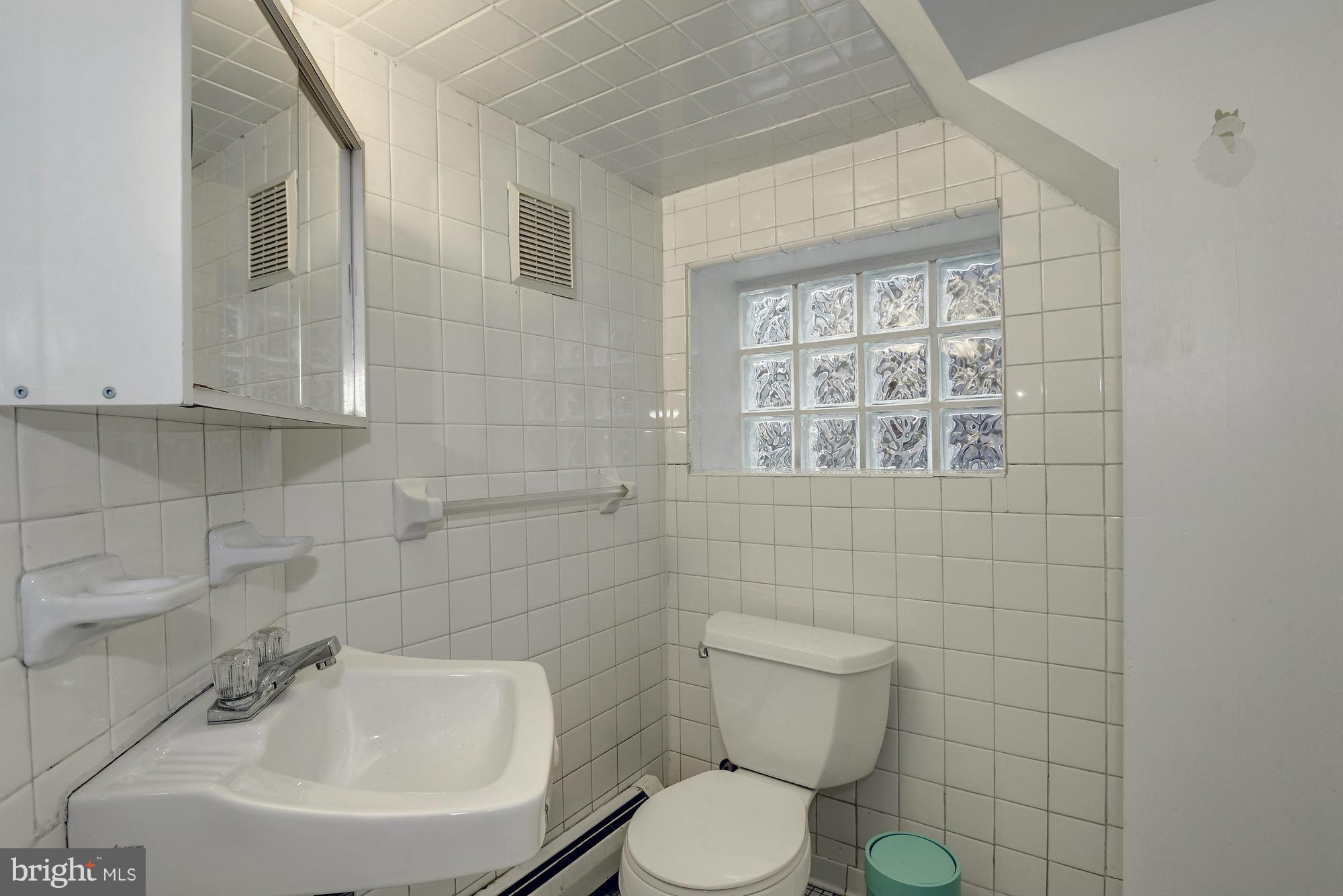 1351 A Street Northeast Washington, DC 20002 - Photo 23 of 26 a bathroom with a toilet a sink and mirror
