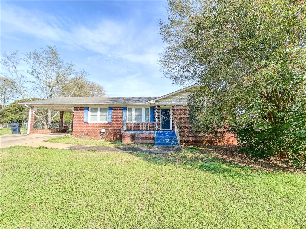 This charming brick home offers convenient covered parking and a welcoming front entrance.