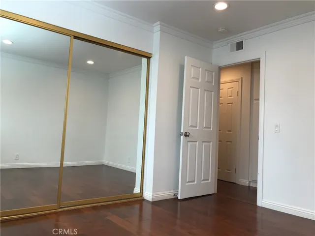 an empty room with wooden floor and closet