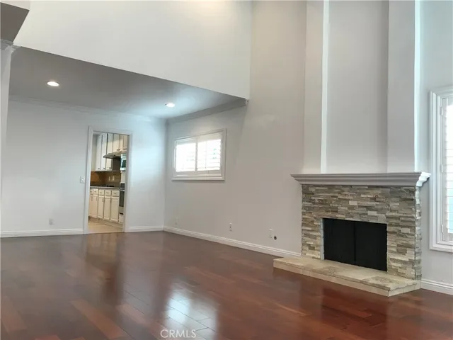 a view of a livingroom with wooden floor and a fireplace