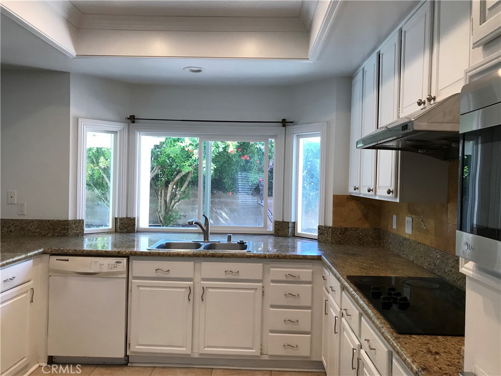 3 Morris Road Irvine, CA 92620 - Photo 7 of 24 a kitchen with granite countertop a sink and white cabinets