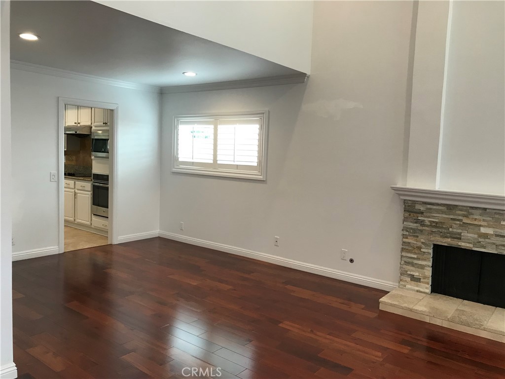 3 Morris Road Irvine, CA 92620 - Photo 9 of 24 an empty room with wooden floor fireplace and windows