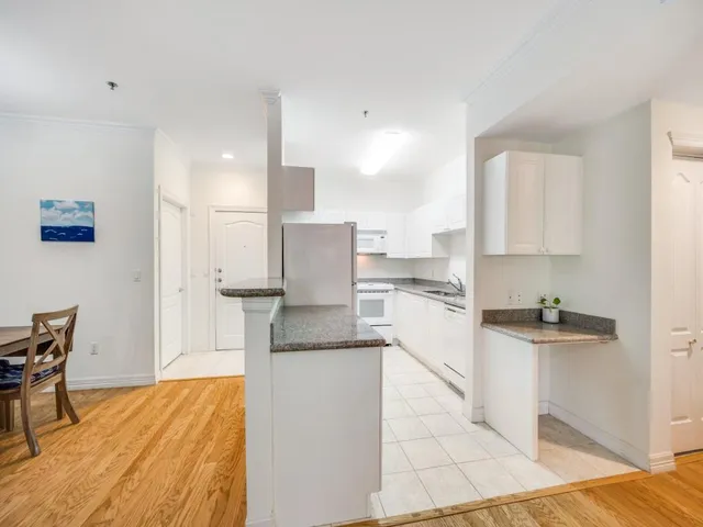 a kitchen with stainless steel appliances kitchen island granite countertop a refrigerator and a stove top oven