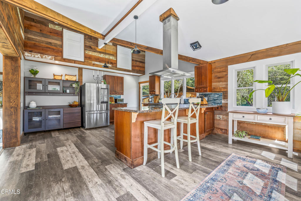 41912 Powers Road Mendocino, CA 95460 - Photo 10 of 48 a dining room with stainless steel appliances a table and chairs with wooden floor